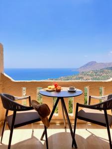 a table and chairs on a balcony with a view at Stella in the Village - Junior Studio Sea View in Plakias