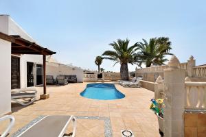 a backyard with a swimming pool and palm trees at Villa Malpas in San Miguel de Abona