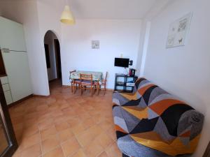 ein Wohnzimmer mit einem Sofa und einem Tisch in der Unterkunft Appartamento Liam in Marzamemi