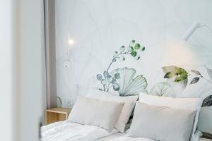 um quarto com paredes brancas e almofadas brancas em Apartament Perłowy Ku Morzu by HolidaySun em Sianozety