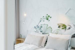 1 dormitorio con paredes blancas y almohadas blancas en Apartament Perłowy z Basenem Letnim by HolidaySun, en Sianożęty