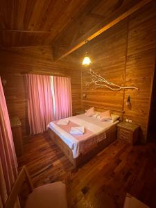 ein Schlafzimmer mit einem Bett in einer Holzhütte in der Unterkunft Sedir Palas in Cıralı