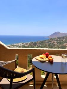 a table with a plate of fruit on top of a balcony at Stella in the Village - Junior Studio Sea View in Plakias