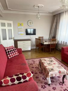 sala de estar con sofá rojo y mesa en Deniz Gören Geniş Aile İçin Uygun Daire en Antalya