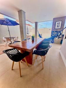 comedor con mesa de madera y sillas en Casa de Luxo na Praia - Sun Luxury Home, en Aracaju