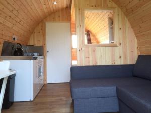 a living room with a couch in a tiny house at Wall Eden Farm - Luxury Log Cabins and Glamping in Highbridge