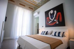 1 dormitorio con 1 cama con una pintura en la pared en Palazzo Ginevra, en Gallico Marina