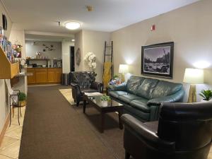uma sala de estar com um sofá de couro e cadeiras em Dillon Inn em Dillon