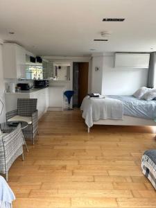 1 dormitorio con 1 cama y suelo de madera en Lovely studio cabin. Hot tub ex £40 per night en Poole