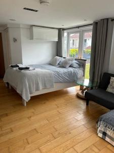 1 dormitorio con cama y mesa de cristal en Lovely studio cabin. Hot tub ex £40 per night, en Poole