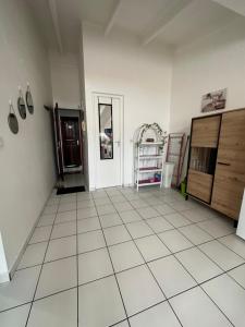 a large room with a white tiled floor and wooden cabinets at Appartements: plage & commerces à 200m in Sainte-Anne