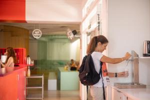 une femme debout dans une cuisine préparant la nourriture dans l'établissement The River Hostel, à Valence