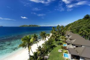 Matamanoa Island Resort في Matamanoa Island: اطلالة جوية على شاطئ به نخيل والمحيط