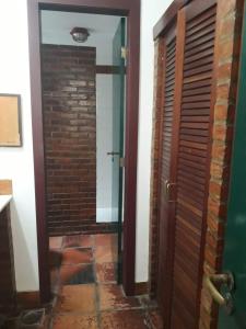 a hallway with a door and a brick wall at Ossos Beach House in Búzios