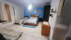 a bedroom with two beds in a room with blue walls at ACONCHEGO DE CANELA/RS in Canela