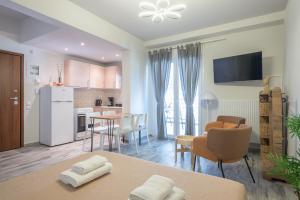 uma cozinha e sala de estar com mesa e cadeiras em Sunny studio with Starlight balcony em Atenas
