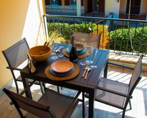 a table with plates and wine glasses on a balcony at Roussev Apartment - Coastal Gem - Anzio in Anzio