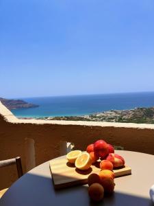 a plate of fruit on a table with a view of the ocean at Stella in the Village Junior Studio Sea View II in Plakias