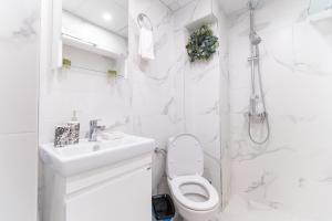 ein weißes Badezimmer mit Toilette und Waschbecken in der Unterkunft Heart of the City 2-Bedroom Apartment in Plowdiw + 20 Fotos