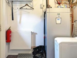 Kleines Zimmer mit einem Kühlschrank und einem Feuerlöscher in der Unterkunft Holiday home MOTALA VI in Motala