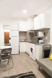 マドリードにあるComodo Y Agradable Apartamento En Madrid Centro 5のキッチン(白いキャビネット、洗濯機、乾燥機付)