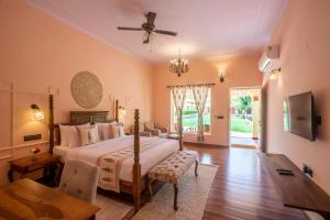1 dormitorio con cama, mesa y TV en Ratan Villas Sariska en Alwar