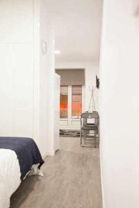 マドリードにあるComodo Y Agradable Apartamento En Madrid Centro 5の白いベッドルーム(ベッド1台、椅子付)