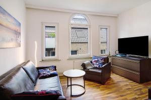 a living room with a couch and a flat screen tv at Villa Fokken Bootsmannsquartier in Esens