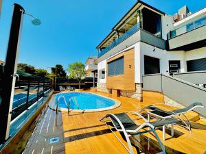 a house with a swimming pool on a wooden deck at SANJA - with a large covered terrace and pool in Banjole