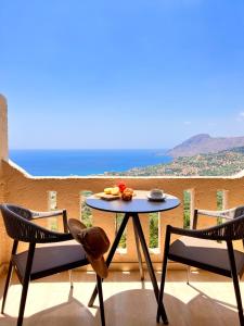 a table and chairs on a balcony with a view of the ocean at Stella in the Village Junior Studio Sea View II in Plakias