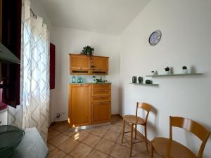 een keuken met houten kasten en een tafel en stoelen bij Il sentiero delle palme in Comiso