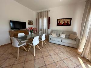 een woonkamer met een bank en een tafel en stoelen bij Il sentiero delle palme in Comiso