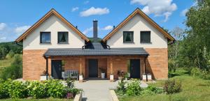 a house with a black roof at Klangor Mechowo in Mechowo