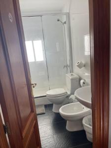 a bathroom with two toilets and a shower and a sink at Casa Calderón in Marbella