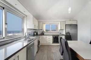 a kitchen with white cabinets and a large window at Villa Atlantico in San Miguel de Abona