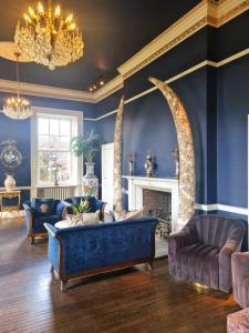 Sala de estar azul con sofá y chimenea en Newton Hall en Chathill