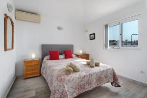 a bedroom with a bed with red pillows and a window at Villa Atlantico in San Miguel de Abona +18 photos
