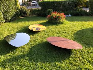 three different colored surfboards sitting on the grass at Arthotel Gabbiano Azzurro Due in Marciana Marina