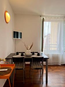 a dining room with a black table and chairs at La Dolce Casa in Bergamo