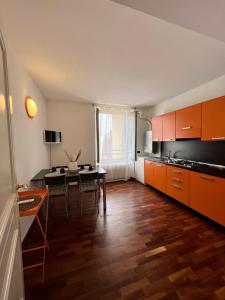 a kitchen with orange cabinets and a dining table at La Dolce Casa in Bergamo