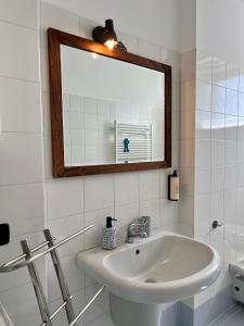 a white bathroom with a sink and a mirror at La Dolce Casa in Bergamo