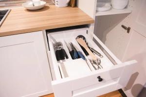 a kitchen drawer with utensils in it at Aizpuri West View in Nīca +6 photos