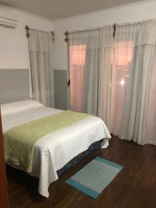 een slaapkamer met een bed, een raam en een tapijt bij Alma costa in Posadas