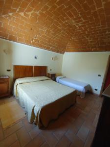 ein Schlafzimmer mit zwei Betten und einer Ziegelwand in der Unterkunft Casa Collarano in San Demetrio neʼ Vestini