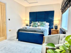 a bedroom with a bed with a blue headboard at Black Swan Mews in Ripon