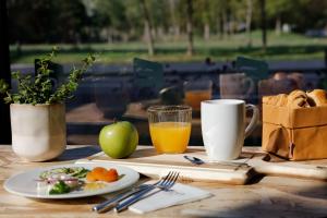 a table with a plate of food and a cup of orange juice at Aloft Strasbourg City Centre in Strasbourg