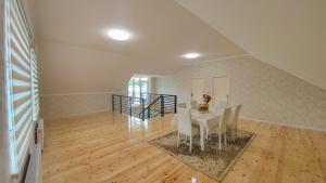 a dining room with a white table and chairs at Qafqaz Flower Villa in Gabala