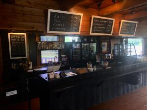 a bar in a pub with signs on the wall at Kätkä Lake Lodge in Tervola