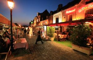 een groep mensen die 's nachts over straat lopen bij un Nid en Ville -Amiens Centre ville avec Parking in Amiens