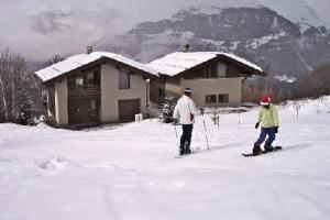 two people on skis in the snow in front of a house at LA PLAGNE MONTALBERT Chalet - fitness - wifi 